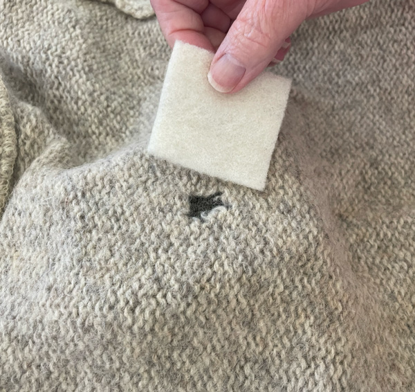 Patched hole on inside of sweater, close up