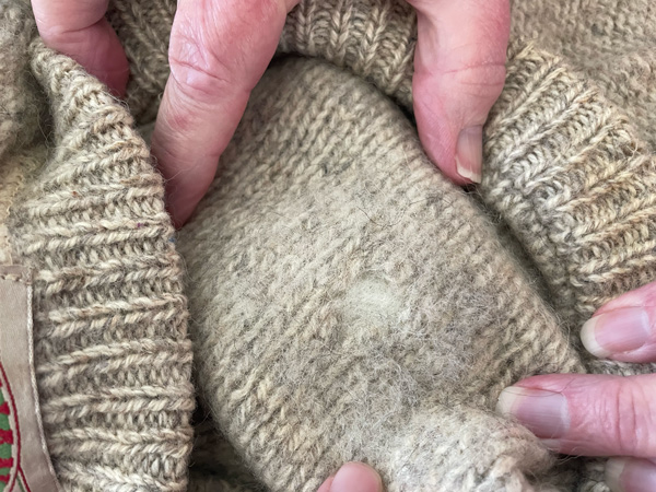 Patched hole on outside of sweater, close up